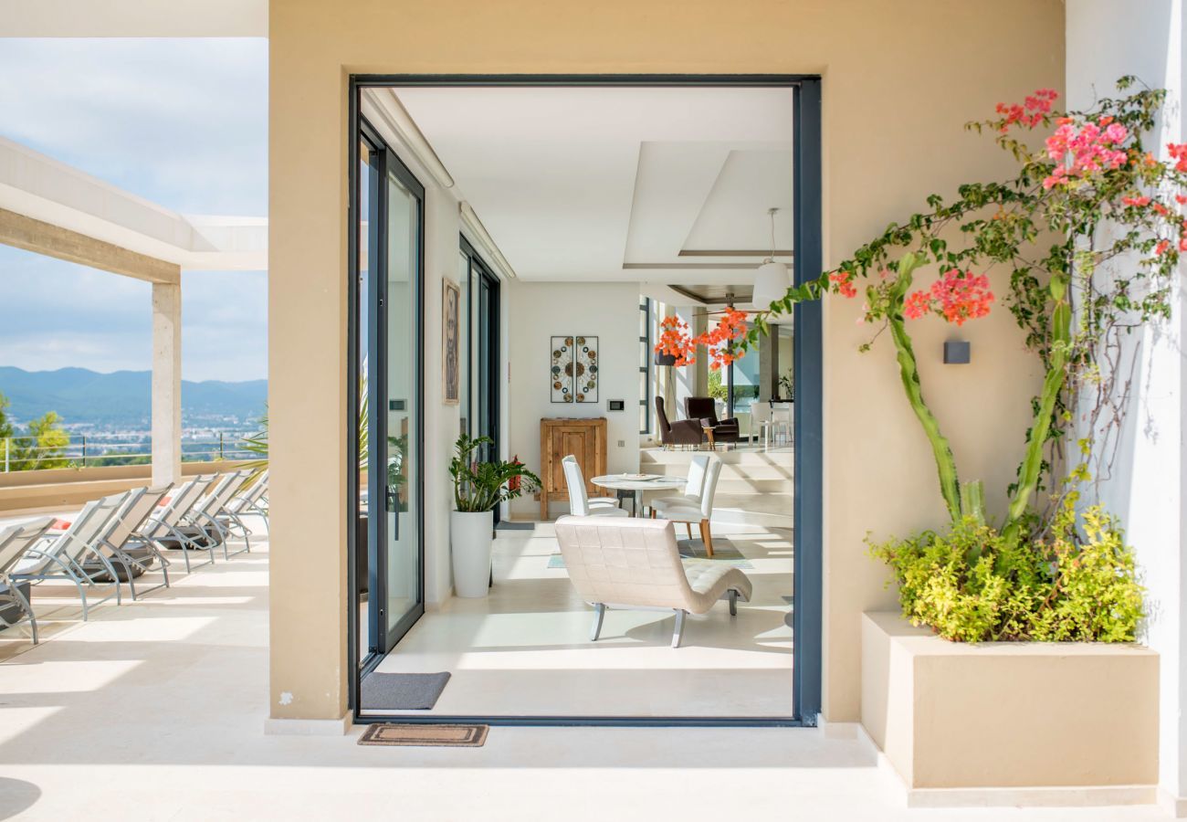 Das Innere der Hilltop-Villa mit großen Fenstern, durch die man die Aussicht auf Ibiza genießen kann.
