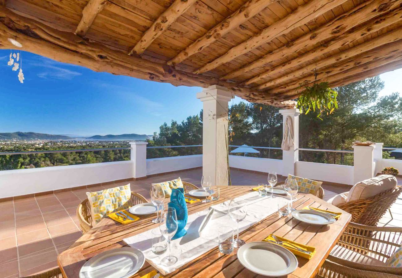 Die Terrasse der Villa Casiopea mit Tischen und Stühlen und Deck, mit Blick auf das Meer.